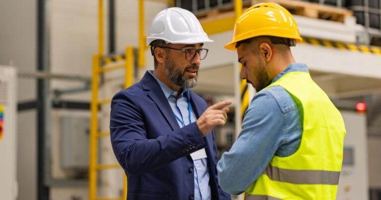 a warehouse worker getting a talking to by supervisor