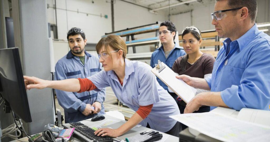 group of new and confused industrial temps crowded around a computer screen