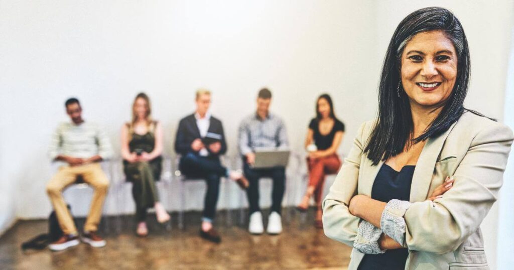 smiling recruiter with interviewees in background