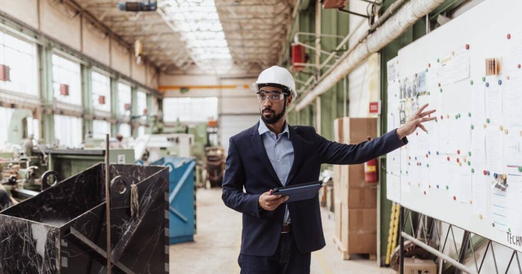 manager standing in front of whiteboard pointing out goals