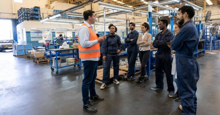 manager leading team meeting on factory floor