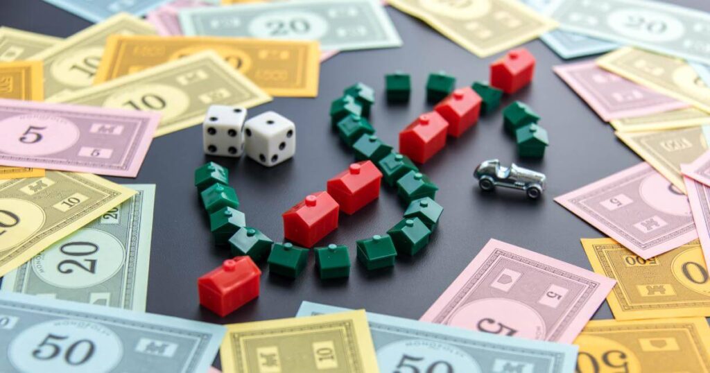 monopoly money with game pieces forming dollar sign